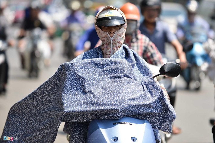 Có người quàng chăn phủ lên toàn bộ chân tay chống nóng, chỉ để hở đôi mắt để điều khiển xe.