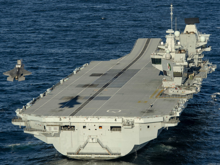 Việc chậm trễ trong quá trình hình thành cụm tàu tác chiến tàu sân bay Queen Elizabeth đến từ việc Mỹ chậm trễ trong chuyển giao số lượng lớn tiêm kích hạm tàng hình thế hệ thứ 5 F-35B cho Anh và việc Hải quân Anh quá thiếu thốn trong đội tàu hộ tống phối thuộc tác chiến. Ảnh: Tiêm kích F-35B hạ cánh xuống tàu sân bay của Anh. Nguồn ảnh: HMS.