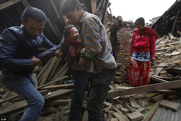 Người đàn ông gào khóc khi hai thanh niên kéo ông ra khỏi ngôi nhà đổ nát tại Bhaktapur. Ảnh: AP.