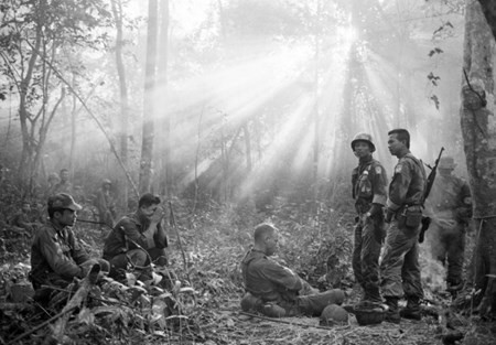 Hãng tin AP thậm chí đã dành được 6 giải Pulitzer cho những tác phẩm đưa tin về Chiến tranh Việt Nam. Hình ảnh ánh nắng xuyên qua tán lá rừng rậm rạp bao quanh thị xã Bình Giã khói lửa, đầu tháng 1/1965. Quân lính chính quyền Sài Gòn xưa cùng các cố vấn Mỹ chờ đợi vật vờ sau khi bị bộ đội Việt Nam phục kích. Ảnh: Horst Faas/AP.