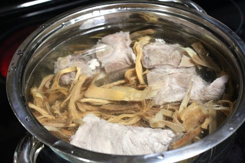 Măng khô hầm xương. Để làm món này có lẽ lâu nhất là công đoạn ngâm và luộc măng nhiều lần. Măng khô xé thành từng sợi vừa ăn rồi ngâm trong nước lạnh khoảng hơn một ngày. Đun nồi nước sôi, thả măng vào luộc qua. Đổ măng lên rổ cho ráo nước.