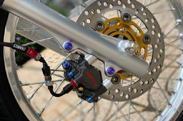 Tiếp đến là những combo nơi phía dàn chân trước, sở hữu heo dầu Brembo Moto3 2 pis đối xứng hơn 30 triệu đồng một con, đi kèm cùng sợi dây dầu Hel Uk bấm đầu. Ngoài ra còn có sự góp mặt của đĩa Brembo Moto3 220mm lòng vàng khá nổi bật.