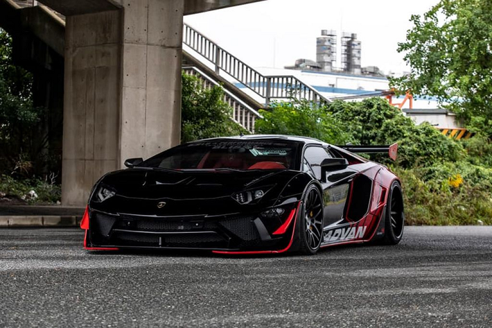 Tông màu chủ đạo của chiếc Lamborghini Aventador độ Liberty Walk này là màu đỏ/đen huyền bí. Sự kết hợp kéo léo về màu sắc đã mang tới hiệu ứng về thị giác là không hề nhỏ. Toàn bộ body-kit của xe cũng được thay đổi so với nguyên bản, nó to, hầm hố và mạnh mẽ hơn rất nhiều với kiểu thiết kế gai góc và lộ đinh đặc biệt. Chưa hết, hộc bánh xe của Aventador cũng được các kỹ sư của Liberty Walk nới rộng và hạ thấp hơn so với tiêu chuẩn.