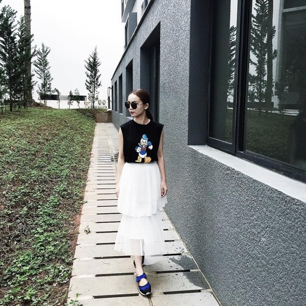 Yến Trang kết hợp váy xếp ly nhiều tầng độc đáo cùng áo phông họa tiết hoạt hình tinh nghịch.