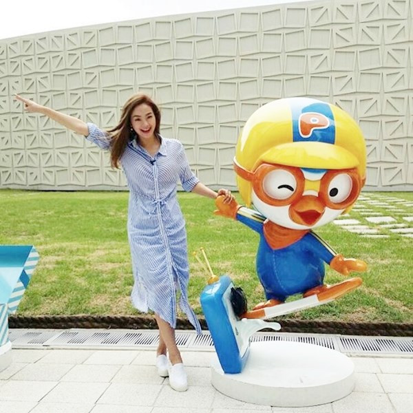 Minh Hằng trẻ trung với đầm sơmi kẻ tăm gam xanh tạo dáng nghịch ngợm trong chuyến công tác nước ngoài.