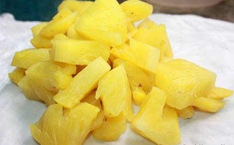 Bước 2: Dứa gọt vỏ, cứa các mắt trên quả dứa, bỏ phần cùi bên trong và cắt miếng nhỏ vừa ăn dọc theo khứa trên thân quả. Sau đó trộn dứa với 1 thìa đường để khi ăn miếng dứa sẽ đậm đà, ngon hơn.