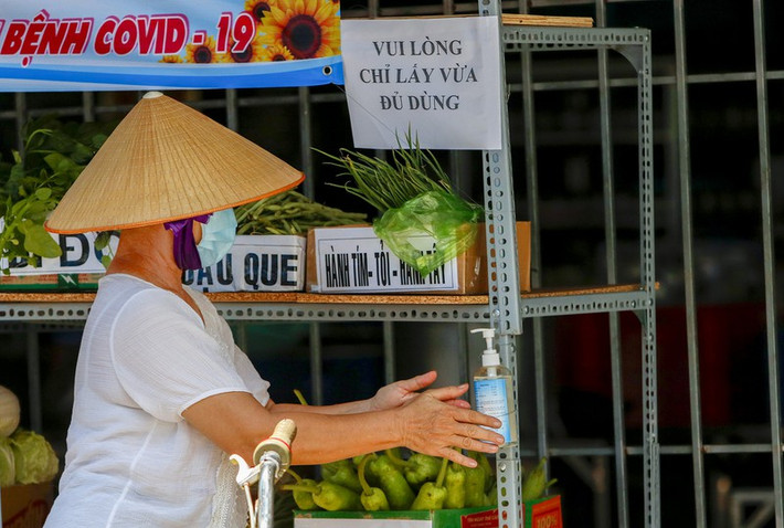 Trước khi nhận thực phẩm, tất cả người dân đều phải sát khuẩn tay.