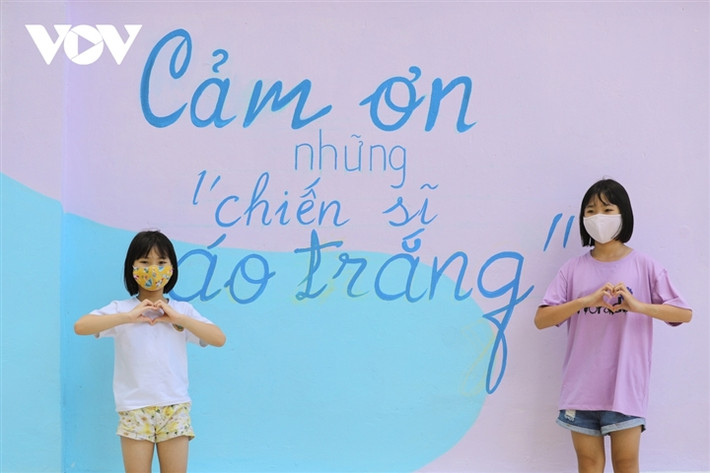 Các em nhỏ được bố mẹ tranh thủ chụp cho kiểu ảnh kỷ niệm với các bức bích hoạ.