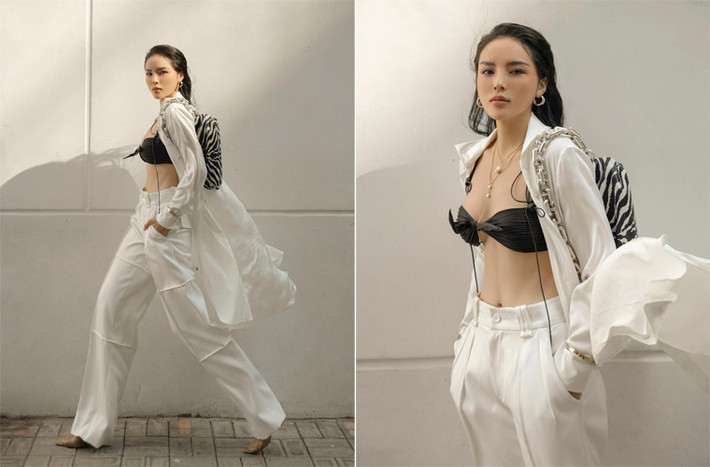 Mặc chiếc quần ống rộng màu trắng, khoác hờ bên ngoài chiếc áo cùng màu, Hoa hậu Việt Nam 2014 gây ấn tượng khi phanh áo để lộ bra đen bên trong.