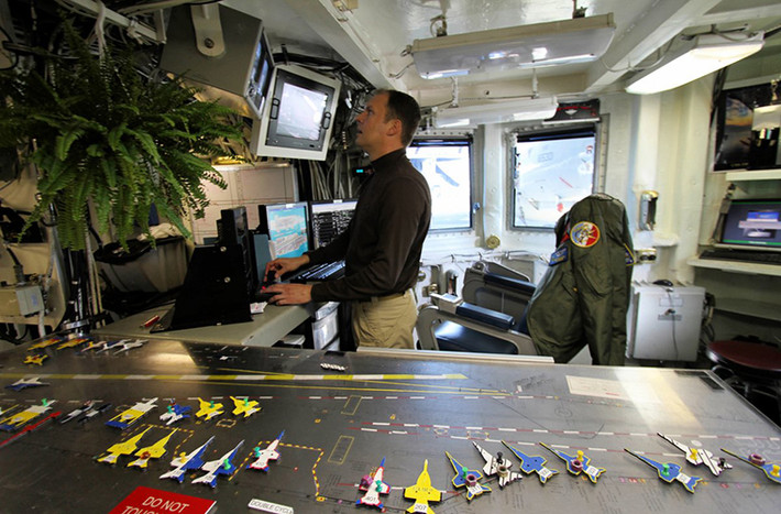 Không khí bên trong trung tâm điều hành bay trên tàu sân bay Mỹ mang tên USS Eisenhower luôn tấp nập như chính trên boong tàu của nó. Toàn bộ hoạt động trên một tàu sân bay đều được thực hiện thông qua tháp chỉ huy và trung tâm điều khiển bay của nó.