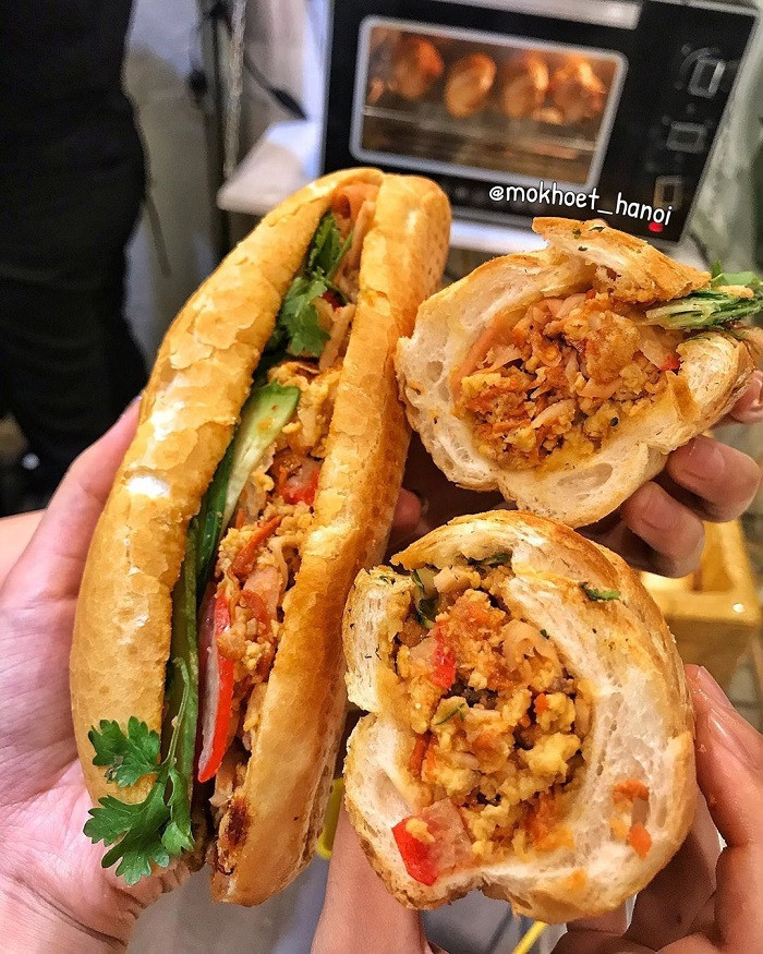 Bánh mì dân tổ từng là món ăn thu hút rất nhiều bạn trẻ bởi thời gian bán phù hợp với các cú đêm và cách chế biến nhân độc đáo không giống bất kỳ hàng bánh mì nào ở Hà Nội. Với giá chỉ từ 15.000 đồng đến 25.000 đồng, bạn đã có trong tay một chiếc bánh mì ú nu với hương vị đặc biệt và hấp dẫn.