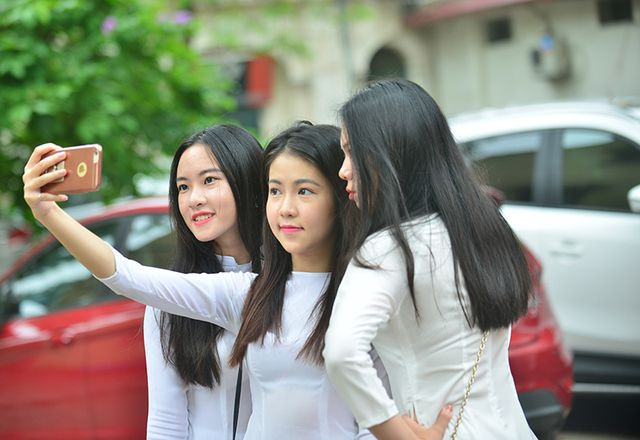 Diện áo dài trắng trơn và thoa chút son, các cô gái không quên lưu giữ những bức ảnh kỉ niệm. "Đẹp không cần son phấn" là bình luận của tài khoản M.T.