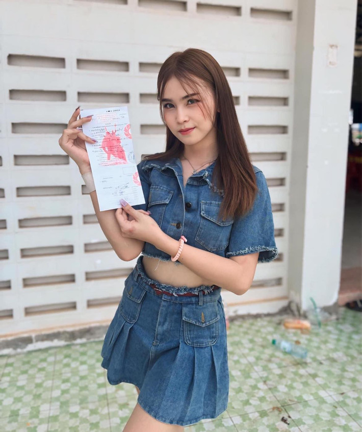 Cô nàng rạng rỡ cầm tờ giấy chứng minh mình đã chuyển đổi giới tính để được miễn nghĩa vụ quân sự.