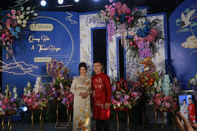 Backdrop cho lễ ăn hỏi cũng được thiết kế tone xanh dương, trang khí hoa tươi xung quanh.