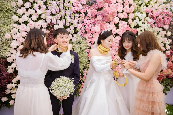 "Gánh nặng" cô dâu mang trên cổ, cầm trên tay không thể xuể nên người thân, bạn bè lại thi nhau đeo lên cổ chú rể.