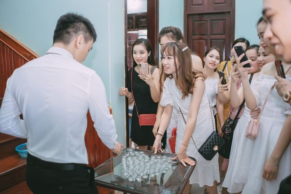 Cụ thể, 49 ly rượu được bày thành hình trái tim được nhà gái đặt trên bục nghỉ cầu thang, và yêu cầu chú rể uống hết các ly mới được đón vợ.
