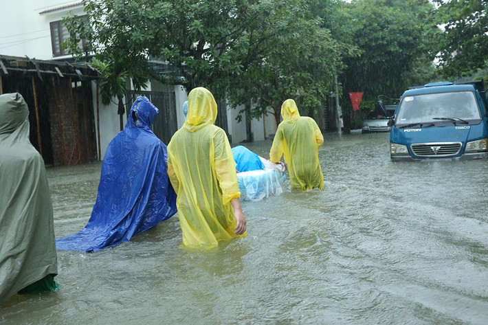 "Sau hơn một tiếng "bơi lội" với mực nước ngang hông có lúc đến ngực, phái đoàn nhà trai cũng đã đến đích trước con mắt trầm trồ của họ nhà gái. Nhưng trời mưa to, lễ vật chỉ còn mang tính kỉ niệm...", tài khoản Hoàng Đạt chia sẻ về đám hỏi đặc biệt.