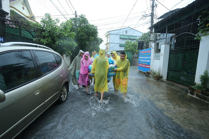 Thậm chí, chú rể cùng những người bạn của mình còn phải đựng lễ vật trong phao và chùm áo mưa lên.