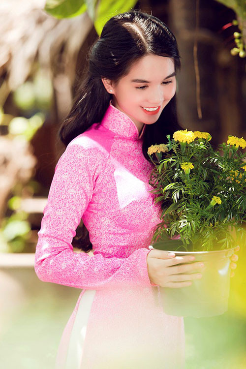 Ngọc Trinh e ấp bên hoa cúc vàng.
