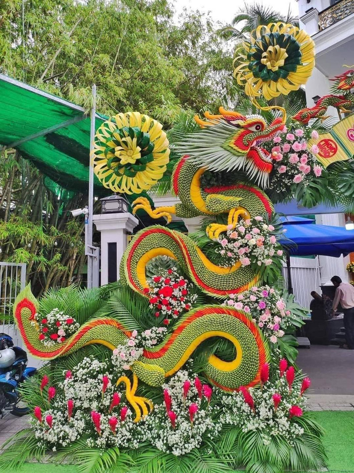 Nguyên liệu chính của chiếc cổng là lá dừa, kết hợp cùng với tre, hoa đã tạo nên thành phẩm ai đi qua cũng phải ngoái nhìn.