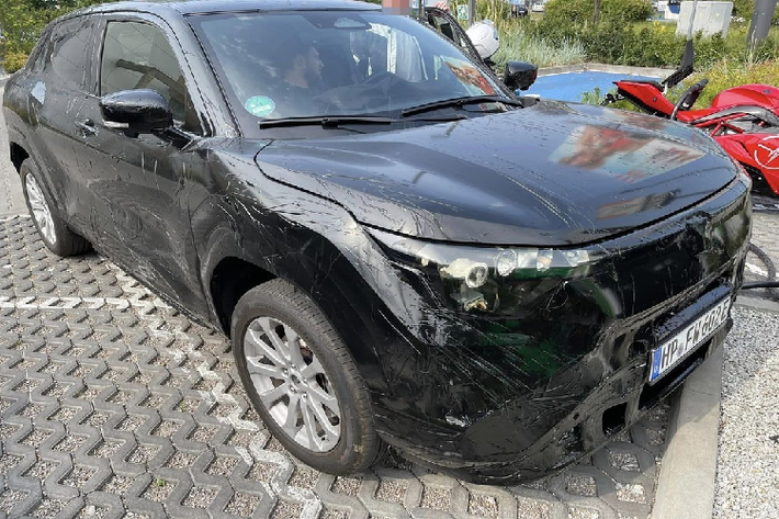 Ở phía sau, mẫu SUV điện nhà Suzuki được trang bị cụm đèn hậu có thiết kế xuyên suốt, nằm vắt ngang đuôi xe. Tương tự ngoại thất, nội thất của chiếc xe điện này cũng được che kín. Chỉ có thể nhận ra một số chi tiết bên trong xe như vô lăng vát 2 đầu, bảng đồng hồ kỹ thuật số nối liền với màn hình cảm ứng trung tâm, cửa gió điều hòa nằm dọc và cụm điều khiển trung tâm có thiết kế đậm chất tương lai.