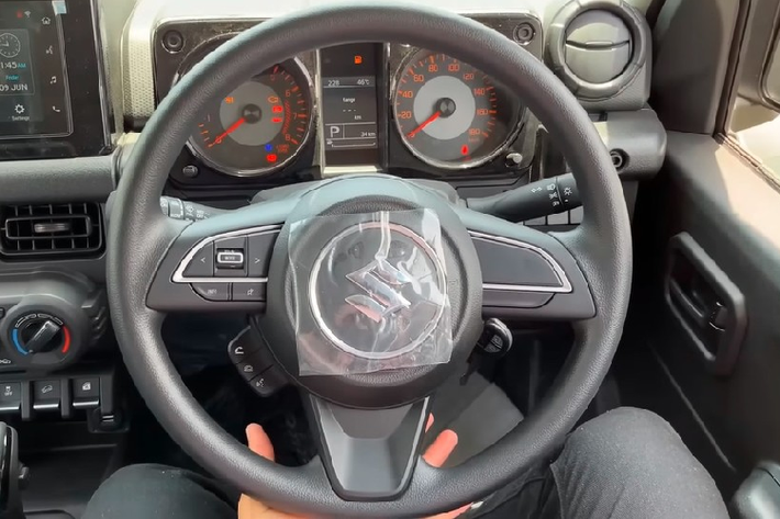 Đằng sau Suzuki Jimny Zeta 5 cửa là cụm đèn hậu nằm trên cản sau và dùng bóng Halogen thông thường. Thêm vào đó là ăng ten thanh que, cửa cốp mở ngang sang bên phải, cần gạt nước/rửa kính sau và sấy kính sau.