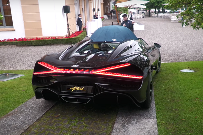 Bugatti Mistral là mẫu siêu xe mui trần thực thụ, hoàn toàn không có mui xếp giống như nhiều mẫu xe khác. Do đó, trong trường hợp xe đang chạy gặp mưa, chỉ còn cách dùng ô như đoạn clip phía trên.