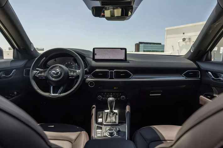 Bên trong Mazda CX-5 2023 tiếp tục giữ nguyên lối thiết kế, xe vẫn sở hữu cụm đồng hồ kỹ thuật số analog, màn hình cảm ứng trung tâm 8 inch tích hợp Apple CarPlay và Android Auto, hệ thống âm thanh Bose 10 loa cao cấp, cửa sổ trời, sạc không dây, màn hình hiển thị kính lái HUD, camera 360 độ, phanh tay điện tử, cốp điện...