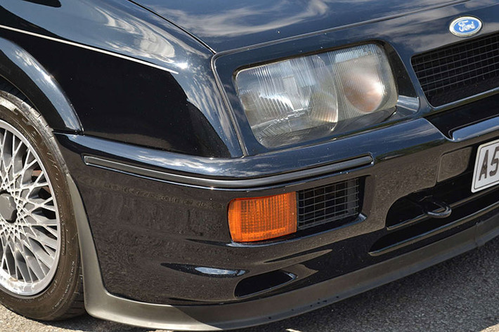 Ford đã tạo ra chiếc Cosworth ba cửa nguyên bản để tương đồng với các mẫu xe sử dụng trong Touring car racing của mình, tung phiên bản tiêu chuẩn ra thị trường vào năm 1986 và chế tạo hơn 5.000 chiếc để làm hài lòng FIA.
