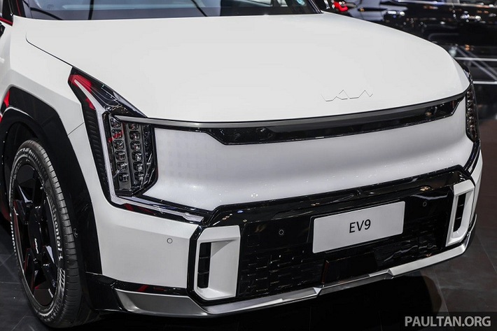 Không chỉ kích thước mà ngay cả thiết kế và trang bị của Kia EV9 GT-Line 2024 cũng không giống bản thường. Có thể thấy rõ điều này qua khu vực đầu xe với cản trước thể thao hơn, đi kèm ốp màu đen bóng và khe gió nổi bật hơn. Bên dưới cản trước còn có thêm ốp gầm màu bạc hầm hố, cùng với đó là lưới tản nhiệt kỹ thuật số (Digital Pattern Lighting Grille) được tích hợp hệ thống đèn ẩn.