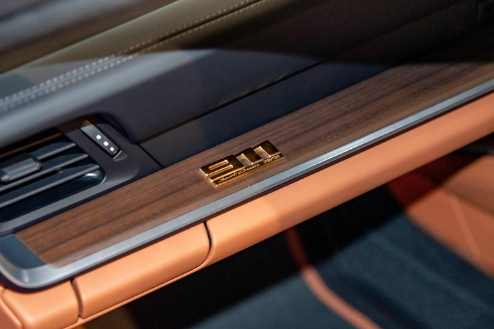Bên trong khoang lái xe thể thao giới hạn Porsche 911 Sport Classic 2023 đầu tiên đặt chân đến Singapore được bọc da Cognac cổ điển sáng màu với các họa tiết Houndstooth, bên cạnh đó còn có các chi tiết ốp bằng gỗ Paldao sẫm màu.