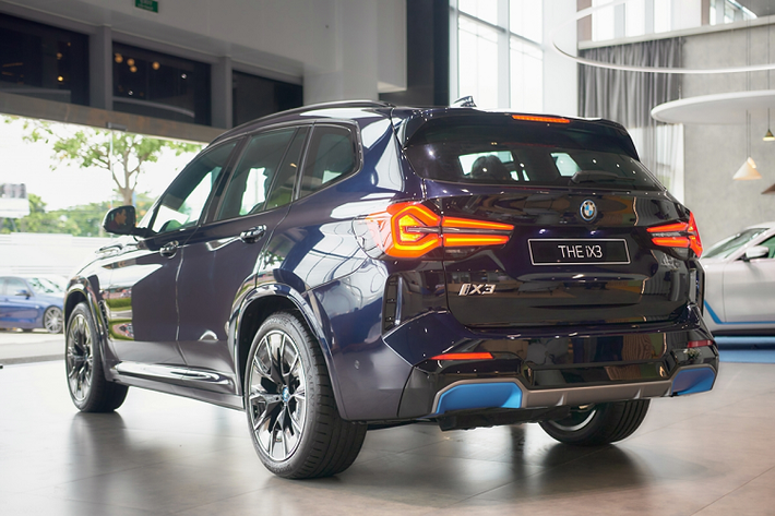 Thiết kế của mẫu xe SUV điện BMW iX3 2023 nổi bật là phần cản trước của xe với lưới tản nhiệt “quả thận kép” đặc trưng, bao quanh là viền Chrome với hiệu ứng ngọc trai (Pearl-Effect) sáng bóng. Hốc gió của xe được thiết kế lớn với điểm khác biệt là viền xanh BMW i Blue để nhận biết các mẫu xe điện BMW