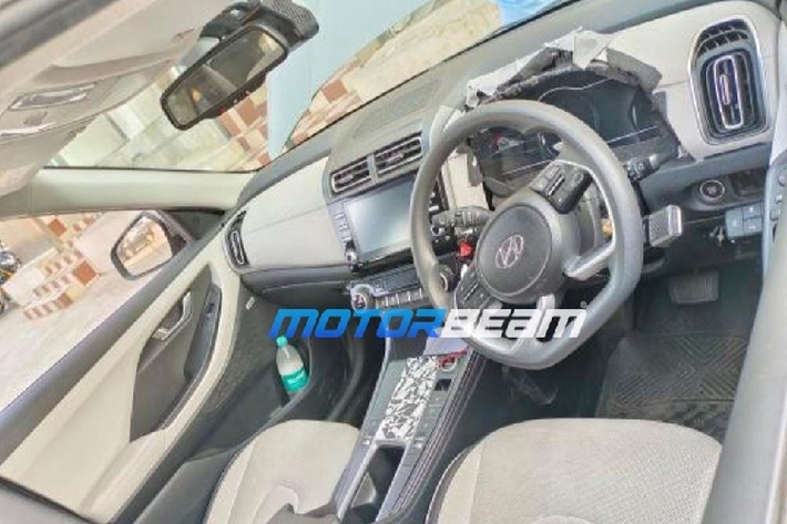 Tương tự nhiều mẫu xe điện đang bán trên thị trường, Hyundai Creta EV cũng dùng núm xoay để chuyển số. Bên cạnh đó là phanh tay điện tử và tính năng tự động giữ phanh tạm thời, giúp khu vực cụm điều khiển trung tâm trở nên gọn gàng hơn. Phía sau vô lăng của Hyundai Creta EV là bảng đồng hồ kỹ thuật số toàn phần thay vì loại analog kết hợp kỹ thuật số như phiên bản máy xăng.