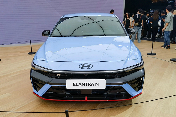 Có vẻ như hãng Hyundai muốn chọn sự kiện đặc biệt hơn là triển lãm Ô tô Thượng Hải để ra mắt phiên bản hiệu suất cao của Elantra. Tương tự bản thường, Hyundai Elantra N 2024 cũng được thay đổi thiết kế ngoại thất. Phần lớn những điểm mới của mẫu sedan cỡ C này đều tập trung vào khu vực đầu xe với lưới tản nhiệt hẹp giữa 2 đèn pha. Bên dưới lưới tản nhiệt là cản trước thể thao, tích hợp hốc gió trung tâm hình thang và khe gió rộng màu đen bóng.
