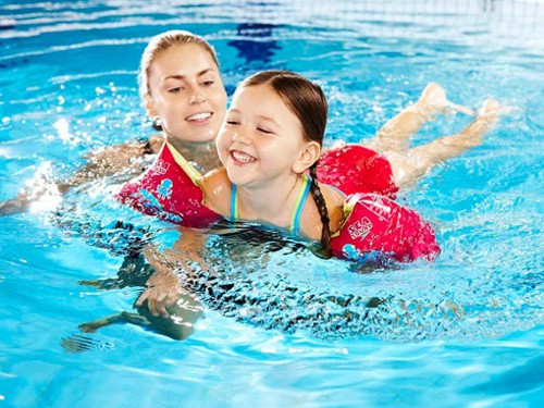 Ban đầu, cho bé tập bơi cùng những vật dụng mềm hoặc đồ chơi để bé thêm thích thú. Sau đó, cha mẹ nên dạy bé tập những động tác cơ bản như đạp chân, đập tay xuống nước. Thỉnh thoảng, hãy dội nước nhẹ nhàng từ đỉnh đầu bé xuống. Ảnh: zing