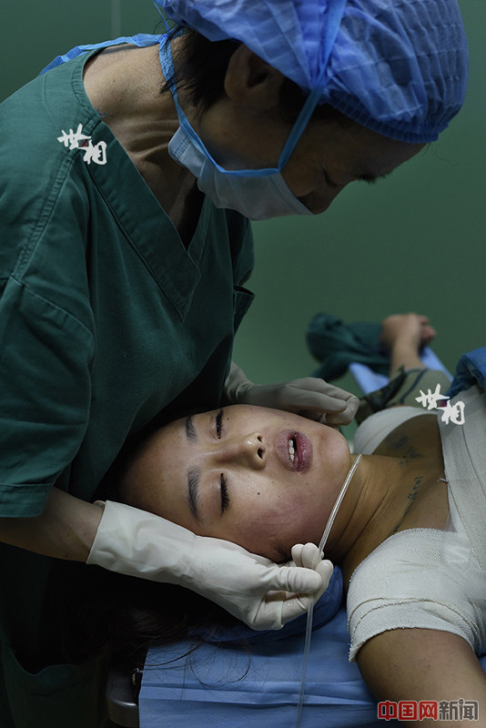 Một bác sĩ gây mê đang hỗ trợ Wang bớt khó chịu và đau đớn sau khi thuốc gây tê hết tác dụng.