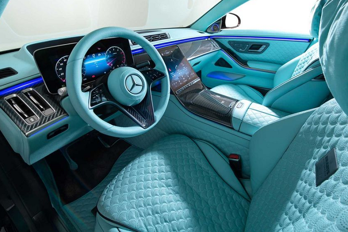 Khoang nội thất của bản độ Brabus 600 Masterpiece mang màu xanh ngọc cực kỳ nổi bật. Các chi tiết như ghế ngồi, bảng điều khiển trung tâm, vô lăng, thảm và tấm lót đầu đều được bọc da màu xanh, kết hợp đường khâu kim cương hình vỏ sò khá thú vị.
