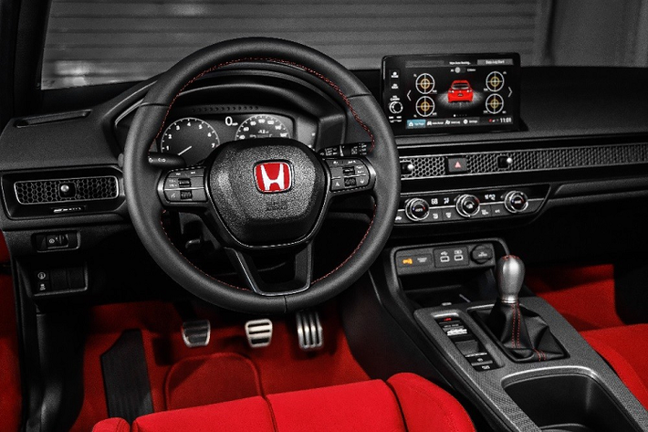 Honda Civic Type R 2023 sở hữu bảng đồng hồ kỹ thuật số 10,2 inch, màn hình thông tin giải trí 9 inch, bộ bàn đạp bằng kim loại, sạc điện thoại thông minh không dây, phanh tay điện tử và tự động giữ phanh tạm thời. Trên tấm lưới tổ ong của cửa gió điều hòa có thêm tấm biển nhỏ đánh dấu số thứ tự xuất xưởng của xe.