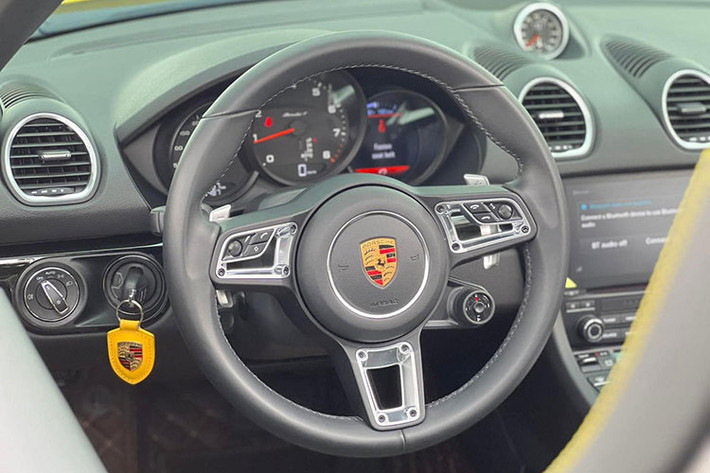 Nội thất của Porsche 718 T được bọc da màu đen kết hợp cùng các chỉ khâu màu vàng trùng màu ngoại thất mang lại cảm giác thể thao. Vô lăng 3 chấu bọc da cao cấp tích hợp nhiều chức năng như đàm thoại rảnh tay là núm chuyển chế độ màn hình, phía sau là lẫy chuyển số. Vì sở hữu gói thể thao Sport Chrono nên phía dưới vô lăng sẽ có một núm vặn chế độ thể thao có tên Sport Response.