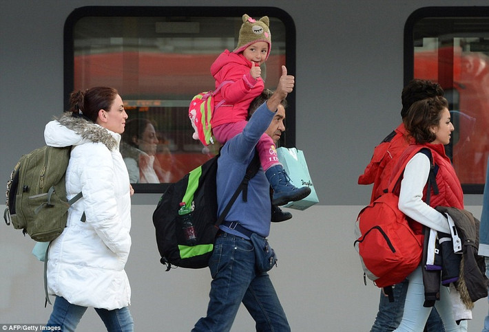 Hai bố con ra hiệu 'hạnh phúc' khi tới Munich sau hành trình đầy khó khăn. (nguồn: Dailymail).