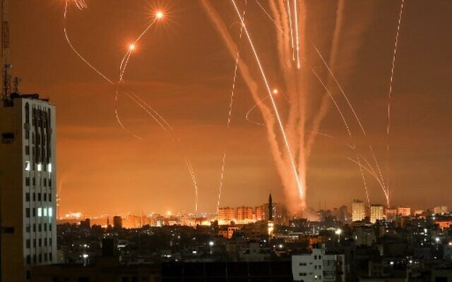 Tên lửa của Hamas thắp sáng bầu trời đêm khi chúng được bắn về phía Israel từ Beit Lahia ở phía bắc Dải Gaza vào đêm ngày 14/5/2021, trong khi các tên lửa đánh chặn Iron Dome của Israel phóng lên để ngăn chặn.