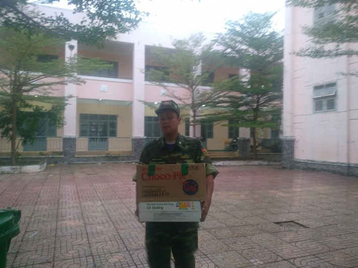 Các anh bộ đội đang bưng thức ăn để chuẩn bị cho bữa cơm tối cho người dân trước thềm con bão.