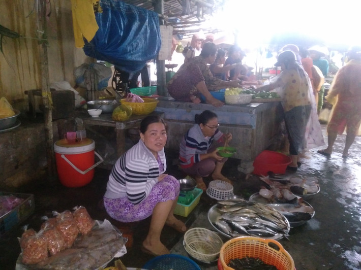 Hàng chục tiểu thương và người dân bình thản ngồi ở chợ đón cơn bão số 9.