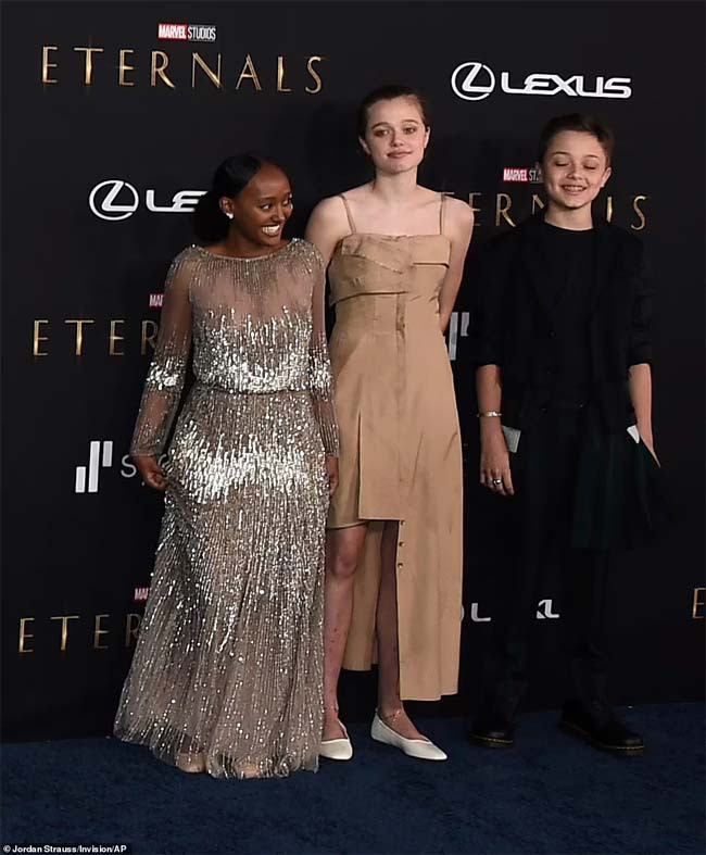 Shiloh - con gái Angelina Jolie của hiện tại đã vô cùng nữ tính khi diện một chiếc váy màu nude, chân đi giày bệt màu trắng và cử chỉ rất e ấp, dịu dàng, khác hẳn với vẻ nam tính mà trước đây cô từng thể hiện. (Ảnh: AP)