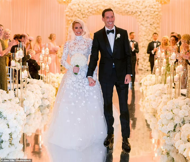 Paris Hilton rạng ngời trong chiếc váy cưới hiệu Oscar de la Renta khoác tay chú rể Carter Reum trên lễ đường. (Ảnh: Shutterstock)