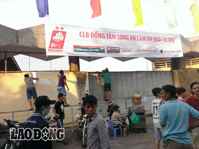 Một vài người leo hàng rào cố nhòm vào sân.