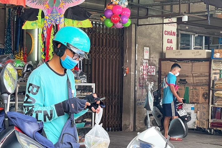 Anh Nguyễn Việt chia sẻ, trong những ngày này anh và các đồng nghiệp luôn “bội thu” đơn hàng, thế nhưng kéo theo đó, những rủi ro cũng luôn thường trực. “Shipper là người mà hàng ngày sẽ đi rất nhiều nơi, tiếp xúc với rất nhiều người. Mặc dù luôn đeo khẩu trang mà mang theo nước sát khuẩn thay, thế nhưng khi nhận đơn và phải xếp hàng dài đợi đồ như thế này, chúng tôi cũng có phần e ngại vì tiềm ẩn nguy cơ lây lan dịch", anh Việt nói.