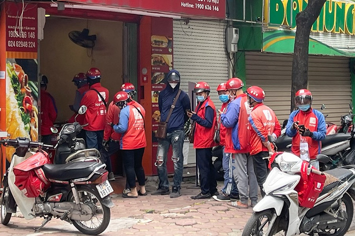 Nóng lòng nhận đồ cho khách, nhiều shipper đã không tuân thủ việc đứng giãn cách theo quy định.