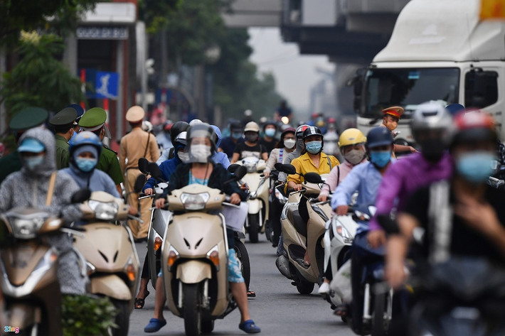 Tại chiều đường từ ngoại thành vào trung tâm thủ đô, lượng xe cộ đông hơn rất nhiều lần so với hướng ngược lại. Để tránh bị ùn tắc giao thông, các chiến sĩ phân chia từng tốp dàn đều dọc theo chiều đường để kiểm tra giấy tờ, không để sót lọt người nào. Ảnh: Hoàng Hà.