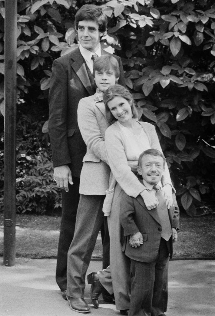 Trong hình là các diễn viên Peter Mayhew, Mark Hamill, Carrie Fisher, và Kenny Baker trong quá trình quay ba bộ phim Star Wars đầu tiên. Bức ảnh được chụp tại Anh vào năm 1980.